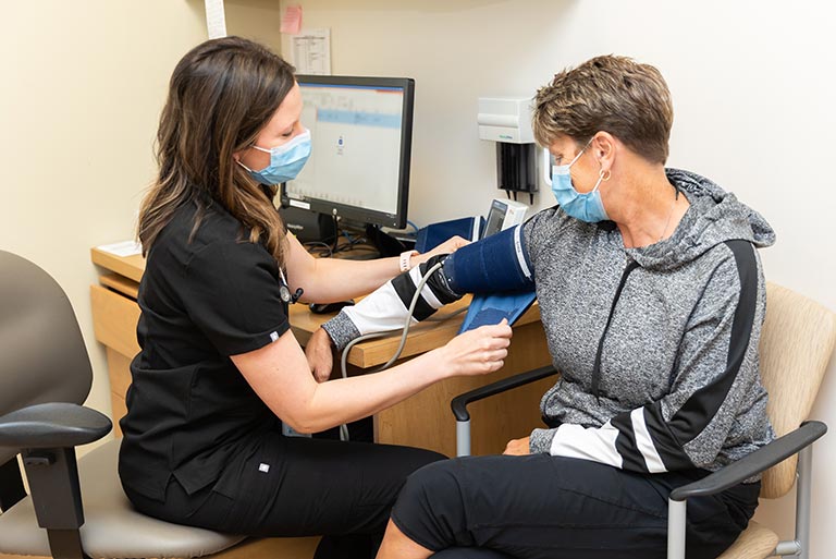 Nurse checks a patients blood pressure during appointment