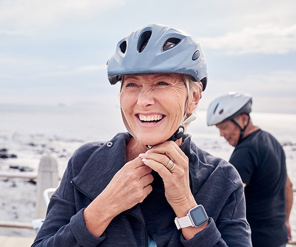 Woman in bike helmet at shore